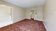 Located at 12036 S Vermont Ave in Los Angeles, CA, this one-bedroom, one-bathroom unit offers a practical and comfortable layout across a single floor. The living room is generously proportioned, featuring warm brown carpeting, neutral cream-toned walls, a textured ceiling, and large windows that allow abundant natural light to fill the space. A front entry door and additional window provide views of the outdoors, enhancing the bright and airy feel of the room.

The galley-style kitchen and dining area is efficiently designed, featuring white tile countertops, a double stainless steel sink, cream cabinetry, a tile backsplash, and light tile flooring. A gas range is included, and the layout maximizes every inch of available space.

The bedroom is a comfortable size, outfitted with plush carpeting, a ceiling fan, a large mirrored sliding closet with overhead storage cabinets, and a window with vertical blinds that invite natural light. The unit includes a total of three closets, offering ample storage throughout.

The bathroom is clean and functional, featuring light tile flooring, a glass-enclosed shower, and a small window for ventilation. A hallway connects the main living areas, completing the unit's well-organized floor plan. Wall-mounted heating units are present in key areas of the home.