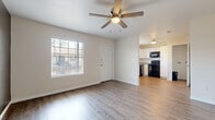 Located in Houston's 77015 zip code, this single-story home presents a clean, updated interior with a consistent design language throughout. The open living area greets you at the entrance, finished with light wood-look luxury vinyl flooring that extends through the main living spaces. A ceiling fan with integrated lighting overhead and a large window dressed with blinds allow natural light to fill the room, creating a bright and welcoming atmosphere.

The kitchen is efficiently designed with white shaker-style cabinetry, granite-look countertops, and a full suite of black appliances including a gas range, microwave, dishwasher, and refrigerator. A window above the sink provides additional natural light. Adjacent utility connections are conveniently accessible nearby.

The bedrooms feature plush carpeting underfoot, ceiling fans, and windows with outdoor views, offering a comfortable and quiet retreat. One bedroom features a notable charcoal accent wall, adding a modern design element to the space.

The bathroom is well-appointed with a white vanity, granite countertop, brushed nickel hardware, and a tub-shower combination finished with marble-style tile surround, complemented by wood-look flooring. Throughout the home, white walls and consistent finishes contribute to a cohesive, move-in-ready aesthetic.