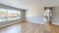 Located at 2130 N Marks Ave in Fresno, California, this single-story, 4-bedroom, 2-bathroom home offers a functional and well-appointed layout. Throughout the home, light-toned luxury vinyl plank flooring provides a clean, cohesive look, complemented by neutral gray walls, crisp white baseboards, and textured ceilings.

The living room is an open, inviting space filled with natural light from a large sliding window that frames views of the surrounding neighborhood. It connects seamlessly to the kitchen via a pass-through opening, enhancing the open feel. The galley-style kitchen is efficiently designed with white shaker cabinetry, dark granite-style countertops, stainless steel appliances including a range and refrigerator, a double sink, and track lighting overhead.

The four bedrooms are comfortably sized, each featuring the same warm LVP flooring, neutral walls, and ample natural light through windowed blinds. The primary bedroom offers a well-proportioned footprint suitable for a full furniture arrangement.

The two bathrooms are cleanly finished: one features a full tub-shower combo with chrome fixtures and white surround, while the second offers a modern vanity with a clean countertop and a glass-enclosed shower. Together, these spaces present a move-in-ready home with a consistent, updated aesthetic throughout.