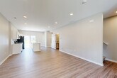 Located on NW Linosa Dr in Waukee, Iowa, this well-designed two-story home offers a thoughtful layout spread across two floors. The main level features a bright, open-concept living room and kitchen, finished with light luxury vinyl plank flooring and recessed lighting throughout. The kitchen is equipped with white shaker cabinetry, stainless steel appliances including a range, microwave, and refrigerator, and a central island with a sink and light countertops. A sliding glass door off the kitchen fills the space with natural light and provides outdoor access. A pantry, hallway, bathroom, and an attached garage with a concrete floor complete the main level. The garage includes interior access through double doors. Upstairs, three bedrooms are carpeted and generously sized, including a primary bedroom with a walk-in closet. Each bedroom benefits from neutral-toned walls and ample natural light. Three full bathrooms serve the home, including one with a tub-shower combo, white vanity, and wood-look flooring. A dedicated upper-level laundry room with washer and dryer hookups adds everyday convenience. The home's clean, modern aesthetic and functional floor plan make it a well-rounded residential space.