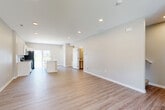 Located on NW Linosa Dr in Waukee, Iowa, this well-designed two-story home offers a thoughtful layout spread across two floors. The main level features a bright, open-concept living room and kitchen, finished with light luxury vinyl plank flooring and recessed lighting throughout. The kitchen is equipped with white shaker cabinetry, stainless steel appliances including a range, microwave, and refrigerator, and a central island with a sink and light countertops. A sliding glass door off the kitchen fills the space with natural light and provides outdoor access. A pantry, hallway, bathroom, and an attached garage with a concrete floor complete the main level. The garage includes interior access through double doors. Upstairs, three bedrooms are carpeted and generously sized, including a primary bedroom with a walk-in closet. Each bedroom benefits from neutral-toned walls and ample natural light. Three full bathrooms serve the home, including one with a tub-shower combo, white vanity, and wood-look flooring. A dedicated upper-level laundry room with washer and dryer hookups adds everyday convenience. The home's clean, modern aesthetic and functional floor plan make it a well-rounded residential space.