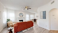 Located at 8181 El Mundo St in Houston, TX, this single-story, one-bedroom, two-bathroom home offers a well-designed layout across a comfortable and functional floor plan. The bright living room serves as the heart of the home, featuring a classic white fireplace, vaulted ceiling accents, a ceiling fan, and light wood-style flooring that extends throughout the main areas. Multiple windows dressed with sheer curtains and blinds invite generous natural light, creating an open and airy atmosphere. The adjacent dining area benefits from its own window with views of surrounding greenery, offering a pleasant spot for everyday meals. The kitchen is outfitted with dark, textured cabinetry, stone-look countertops, a tile backsplash, and stainless steel appliances including a side-by-side refrigerator and built-in microwave. The generously sized bedroom features plush carpet flooring, a ceiling fan, and ample natural light. A spacious walk-in closet with extensive wire shelving provides abundant storage. The en-suite bathroom includes a dual-sink vanity with white cabinetry and large mirrors. A second full bathroom and a dedicated laundry area with a stacked washer and dryer complete this well-appointed home.