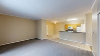 This well-appointed 2-bedroom, 2-bathroom single-floor residence at 54 Hunt Club Dr in Copley, Ohio offers a thoughtfully designed layout with a comfortable, functional flow throughout. The open-concept living and dining area is anchored by plush carpeting and crown molding details, creating a welcoming atmosphere. The kitchen seamlessly integrates with the living space via a peninsula bar featuring dark countertops, providing both additional prep space and a natural divider. Light wood cabinetry, white appliances, and tile flooring complete the kitchen's practical design. A hallway connects the bedrooms and bathrooms to the main living areas. Both bedrooms feature soft carpeting, neutral tones, and ample natural light from windows with blinds. The primary bedroom is generously sized and includes a spacious walk-in closet with wire shelving on both sides. The second bedroom also offers closet storage with bifold doors. Both bathrooms are finished with tile flooring, vanities with wood cabinetry, and tub-shower combinations. An in-unit laundry area adds everyday convenience, while a private patio provides outdoor access. With six total closets throughout, storage is plentiful, rounding out this comfortable and efficiently designed home.