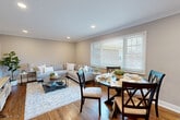 Located at 14 Bliss Ave in Tenafly, NJ, this well-appointed one-bedroom, one-bathroom unit offers a thoughtfully designed single-floor layout. Rich hardwood floors and elegant crown molding flow throughout the main living areas, lending a polished, cohesive aesthetic.

The combined living and dining room serves as the heart of the home, bathed in natural light from large windows with blinds. Recessed ceiling lights provide ample illumination, while neutral warm-gray walls create a versatile backdrop. The living area offers comfortable lounging space, and the dining area accommodates a full-sized round table and chairs.

The kitchen is outfitted with crisp white shaker cabinetry, stainless steel appliances including a gas range, refrigerator, and microwave, and stone-look tile flooring. A convenient in-unit stacked washer and dryer is tucked neatly behind louvered doors just off the kitchen, alongside additional pantry storage.

The bedroom is a tranquil retreat featuring hardwood floors, a ceiling fan, recessed lighting, and a generous window overlooking greenery. Crown molding continues into this room, maintaining the refined character found throughout.

The bathroom includes a clean, white-tiled tub-shower combination with chrome fixtures. A closet rounds out the unit's functional storage offerings.