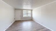 Located at 600 E Inskip Dr in Knoxville, Tennessee, this two-bedroom, one-bathroom single-floor unit offers a practical and well-organized layout. Throughout the home, durable wood-look vinyl flooring and neutral gray walls create a clean, cohesive aesthetic, complemented by crown molding and textured ceilings.

The living room is bright and open, featuring a large window that brings in natural light and a welcoming entry door. Both bedrooms are comfortably sized — the primary bedroom includes a ceiling fan with light fixture, a window with outdoor views, and built-in low shelving along one wall. The second bedroom also features a ceiling fan and a window for natural light.

The kitchen is equipped with white cabinetry, dark countertops, a double sink, and white appliances including an electric range and refrigerator. A tray ceiling detail adds architectural interest overhead. A hallway connects the kitchen to the rest of the unit, where built-in shelving provides additional storage.

A dedicated laundry room includes a full-size washer and dryer, overhead white cabinetry, and a water heater — offering convenient in-unit utility. The bathroom features a combined tub and shower with chrome fixtures. This unit provides efficient, functional living in a straightforward single-level floor plan.