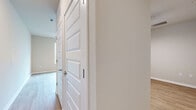 Located at 4902 Cosmos Circle in Wimauma, Florida, this efficiently designed single-floor space offers a clean, modern aesthetic with a thoughtful layout. Light wood-look flooring runs throughout, creating a cohesive and bright atmosphere across every room.

The open-concept kitchen and living area serves as the heart of the unit. The kitchen is well-appointed with white cabinetry, a full suite of stainless steel appliances including a refrigerator with ice maker, electric range, and over-the-range microwave, plus a peninsula counter that provides additional workspace and a natural division between the kitchen and living area. Large windows along one wall flood the space with abundant natural light, enhancing the airy, open feel of the room. Recessed lighting and a ceiling fan add functionality and comfort overhead.

The bedroom area features warm neutral-toned walls and a high clerestory window that brings in additional natural light while maintaining privacy. A dedicated closet with panel-style double doors provides organized storage.

The full bathroom is clean and modern, featuring a walk-in glass-door shower, a white vanity with ample cabinet storage, a framed mirror, and consistent wood-look flooring. The neutral palette and simple finishes throughout the space lend it a fresh, move-in-ready appeal.