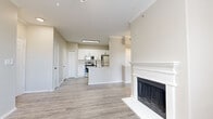 This well-appointed one-bedroom, one-bathroom residence in Lewisville, TX offers a thoughtfully designed single-floor layout. The open-concept living and kitchen area serves as the heart of the home, anchored by a classic white-mantled fireplace that adds warmth and character. Durable wood-look flooring flows throughout the entire space, complemented by crown molding and neutral-toned walls that create a bright, cohesive aesthetic.

The kitchen is equipped with white shaker-style cabinetry, light quartz countertops, a tile backsplash, and a full suite of stainless steel appliances including a range, microwave, and refrigerator. A peninsula with a built-in sink provides additional prep space and casual seating potential. A dedicated laundry area and a closet add everyday convenience.

The bedroom offers a comfortable footprint with a ceiling fan, a window with natural light and outdoor views, and direct access to a walk-in closet with built-in shelving. The bathroom features a dual-sink vanity with white cabinetry, quartz countertops, and navy hardware accents, lending a modern touch. Throughout the space, the clean, neutral palette and consistent flooring create a cohesive and move-in-ready environment.