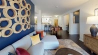 This single-floor residence offers a thoughtfully designed layout that balances style and functionality throughout. The open-concept living and dining area serves as the heart of the home, featuring rich dark hardwood flooring, a bold navy accent wall adorned with circular wood art, and seamless sightlines into the kitchen — creating a connected and inviting atmosphere.

The galley-style kitchen is well-equipped, showcasing white shaker cabinetry with brushed nickel hardware, granite countertops, a gray subway tile backsplash, and stainless steel appliances. Ample upper and lower cabinet storage maximizes the space efficiently.

The primary bedroom features plush carpeting, a warm golden accent wall, a ceiling fan, and a window that invites natural light. The en-suite bathroom is finished with white cabinetry, granite countertops, dark hardwood flooring, and a walk-in shower. Additional bedrooms are equally comfortable, each with carpet flooring, ceiling fans, natural light from large windows, and distinct accent wall details. A second full bathroom includes a granite-topped vanity, white cabinetry, dark hardwood floors, and a shower-tub combination. Throughout the residence, consistent finishes and carefully considered design details contribute to a cohesive and modern living experience.