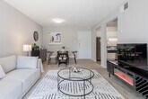 This single-floor residence in Richmond, Virginia offers a well-organized and comfortable layout. The living room is a welcoming focal point, featuring large sliding glass doors that flood the space with natural light and provide direct access to an outdoor balcony with views of the surrounding greenery. Soft carpeting and a textured ceiling add warmth to the room, which flows openly into a dedicated dining area complete with carpet flooring and wall décor accents.

The kitchen is efficiently designed with white cabinetry, dark granite-style countertops, a double-basin stainless steel sink, and stainless steel appliances including a gas range and dishwasher. Tile flooring and under-cabinet lighting enhance both function and aesthetics.

The primary bedroom is a serene retreat featuring a shiplap-style accent wall, plush carpet, a broad window dressed with rich blue curtains, and ample natural light. A second bedroom offers versatility with its own shiplap accent wall, striped area rug, and a loft-style bed frame that creates space for a built-in desk workspace below—ideal for study or remote work.

The bathroom is clean and bright, featuring tile flooring, a tub-shower combination, and a vanity with dark countertops. Throughout the residence, a neutral color palette and consistent finishes create a cohesive and inviting atmosphere.