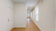This single-floor, 3-bedroom, 2-bathroom home offers a thoughtfully designed layout with modern finishes throughout. The open-concept kitchen and living area serves as the heart of the home, featuring light hardwood flooring, recessed lighting, and a ceiling fan. The kitchen is equipped with stainless steel appliances, dark walnut cabinetry, a subway tile backsplash, and a granite-topped island with an undermount sink — ideal for both cooking and entertaining. The living area extends toward a rear glass door, allowing natural light to fill the space.

A wide hallway connects the main living area to the bedrooms, lined with windows dressed in white blinds that provide a bright, airy feel. The primary bedroom features hardwood flooring, dual windows, and a ceiling fan, while the secondary bedrooms are finished with plush carpeting, ceiling fans, and natural light from individual windows. Three closets offer ample storage throughout.

The two bathrooms are finished with granite countertops and dark walnut cabinetry. One bathroom includes a soaking tub with tiled surround, while the other features a glass-enclosed walk-in shower. Both share the same warm wood-look flooring and brushed nickel fixtures, creating a cohesive, contemporary aesthetic across the entire home.
