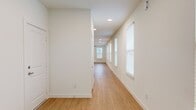 This single-floor, 3-bedroom, 2-bathroom home offers a thoughtfully designed layout with modern finishes throughout. The open-concept kitchen and living area serves as the heart of the home, featuring light hardwood flooring, recessed lighting, and a ceiling fan. The kitchen is equipped with stainless steel appliances, dark walnut cabinetry, a subway tile backsplash, and a granite-topped island with an undermount sink — ideal for both cooking and entertaining. The living area extends toward a rear glass door, allowing natural light to fill the space.

A wide hallway connects the main living area to the bedrooms, lined with windows dressed in white blinds that provide a bright, airy feel. The primary bedroom features hardwood flooring, dual windows, and a ceiling fan, while the secondary bedrooms are finished with plush carpeting, ceiling fans, and natural light from individual windows. Three closets offer ample storage throughout.

The two bathrooms are finished with granite countertops and dark walnut cabinetry. One bathroom includes a soaking tub with tiled surround, while the other features a glass-enclosed walk-in shower. Both share the same warm wood-look flooring and brushed nickel fixtures, creating a cohesive, contemporary aesthetic across the entire home.