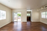Located at 10878–10898 Church St in Rancho Cucamonga, CA, this single-floor residence offers a well-organized layout with a clean, modern aesthetic throughout. The open living area is a standout feature, showcasing rich, warm-toned hardwood flooring that extends throughout the main living spaces. Natural light pours in through multiple windows and a sliding glass door that opens onto a private outdoor patio, creating a bright and welcoming atmosphere. Track lighting accents the living area, adding both functionality and style.

The kitchen is thoughtfully appointed with warm cherry wood cabinetry, granite-style countertops, and black appliances including a gas range, microwave, and refrigerator. Hardwood flooring continues seamlessly into this space, maintaining a cohesive look.

The bedrooms feature plush carpeting and are generously sized. The primary bedroom includes a walk-in closet and direct access to an en-suite bathroom, as well as a ceiling fan for added comfort. The bathroom is finished with a rich cherry wood vanity, granite-style countertops, and a full shower-tub combo with clean white surrounds. A second bathroom mirrors the same quality finishes.

The entryway provides convenient closet storage, and the overall layout flows intuitively from the living spaces into the private areas, making this a practical and comfortable single-floor residence.