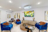 Located at 42280 Garfield Rd in Clinton Township, Michigan, this thoughtfully designed single-floor facility offers a generous and well-appointed layout across its expansive footprint. The space is organized to support both social gathering and everyday functionality.

The welcoming entrance lobby immediately sets an upscale tone, featuring light hardwood flooring, elegant crystal chandeliers, and stylish blue velvet accent chairs arranged around a circular glass coffee table. Vibrant abstract wall art and a wall-mounted flat-screen TV add visual interest, while a credenza with decorative accents completes the refined atmosphere.

The spacious dining room is a standout feature, accommodating multiple dining tables set with lantern centerpieces and neatly upholstered gray chairs with wood-tone legs. Tray ceilings with recessed lighting and a crystal chandelier lend architectural sophistication, while large windows dressed with warm-toned drapes invite natural light throughout.

A dedicated meeting room provides a more intimate setting, centered around a striking oval marble-top table surrounded by plush gray swivel chairs and equipped with a wall-mounted display screen — ideal for private discussions or presentations.

Connecting these areas is a bright, open hallway with light hardwood flooring, crystal overhead lighting, and a clean, modern aesthetic that ties the entire space together cohesively.