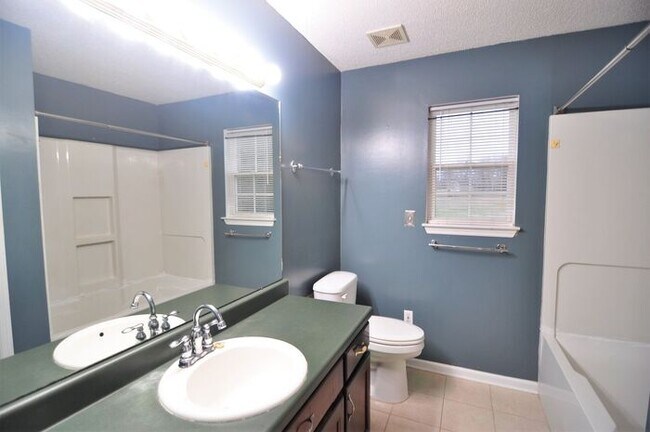 Building Photo - Comfortable with nearly an acre fenced yard.