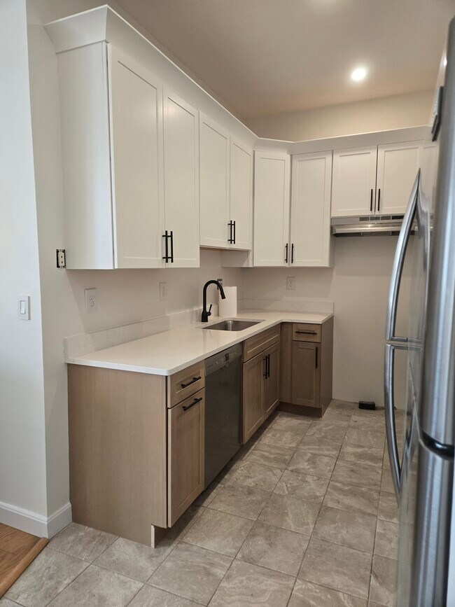 Cocina con gabinetes nuevos, electrodomésticos de acero inoxidable y encimeras de cuarzo nuevas. - 64 Forest St