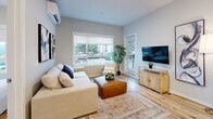Located at 2165 Benvoulin Crt in Kelowna, BC, this well-designed 3-bedroom, 2-bathroom unit offers a thoughtfully organized single-floor layout with modern finishes throughout. The open-concept kitchen and living area serves as the heart of the home, featuring white shaker-style cabinetry extending to the ceiling, stainless steel appliances, and a central island with a white quartz countertop and bar seating — ideal for dining or entertaining. Light hardwood flooring flows seamlessly throughout the space, complementing the soft grey walls and recessed lighting. The living room is bright and inviting, with large windows that draw in natural light and provide outdoor views, a wall-mounted mini-split unit, and direct access to a private balcony. The primary bedroom is a comfortable retreat with a large window overlooking the surroundings, while the additional bedrooms are well-proportioned and similarly finished. Both bathrooms are clean and contemporary, featuring white vanities with undermount sinks, chrome hardware, and full tub-shower combinations with hardwood-look vinyl flooring. A dedicated closet provides added storage. The overall ambiance is clean, bright, and modern — well-suited for functional everyday living.