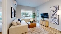 Located at 2165 Benvoulin Crt in Kelowna, BC, this well-designed 3-bedroom, 2-bathroom unit offers a thoughtfully organized single-floor layout with modern finishes throughout. The open-concept kitchen and living area serves as the heart of the home, featuring white shaker-style cabinetry extending to the ceiling, stainless steel appliances, and a central island with a white quartz countertop and bar seating — ideal for dining or entertaining. Light hardwood flooring flows seamlessly throughout the space, complementing the soft grey walls and recessed lighting. The living room is bright and inviting, with large windows that draw in natural light and provide outdoor views, a wall-mounted mini-split unit, and direct access to a private balcony. The primary bedroom is a comfortable retreat with a large window overlooking the surroundings, while the additional bedrooms are well-proportioned and similarly finished. Both bathrooms are clean and contemporary, featuring white vanities with undermount sinks, chrome hardware, and full tub-shower combinations with hardwood-look vinyl flooring. A dedicated closet provides added storage. The overall ambiance is clean, bright, and modern — well-suited for functional everyday living.