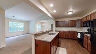 Located at 223 Reserve Way in Harrisburg, PA, this well-appointed 2-bedroom, 2-bathroom single-floor residence offers a thoughtfully designed layout ideal for comfortable living. The open-concept kitchen is a standout feature, showcasing rich dark wood cabinetry, granite countertops, a tile backsplash, hardwood-style flooring, and a center island with a built-in sink — all flowing seamlessly into the living room, which is bathed in natural light from multiple windows. The living area offers a warm, inviting atmosphere with plush carpeting throughout. Both bedrooms are generously sized, featuring neutral tones, soft carpet, and large windows that frame lush outdoor greenery. The primary bedroom includes a walk-in closet with wire shelving for ample storage. Three closets in total provide excellent organizational capacity throughout the home. The two bathrooms are finished with tile flooring, wood vanities, and clean, neutral fixtures. A dedicated in-unit laundry room with full-size washer and dryer adds everyday convenience. Additional wire shelving in the laundry area maximizes utility. The home also includes a private patio, perfect for enjoying the outdoors.