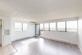 Located at 14255 Boulevard Gouin Ouest in Montréal, this well-organized 2-bedroom, 2-bathroom unit offers a practical and comfortable layout across a single floor. Light grey laminate flooring flows consistently throughout the main living areas and bedrooms, creating a clean, cohesive aesthetic. The spacious living room is bathed in natural light through large windows and sliding glass doors that open onto a balcony, offering expansive panoramic views of the surrounding landscape and waterway. A wall-mounted air conditioning unit ensures year-round comfort. The kitchen features a classic U-shaped layout with abundant white cabinetry, white tile backsplash, neutral countertops, and light ceramic tile flooring — offering generous storage and workspace. The primary bedroom is a comfortable size, with soft grey walls, light flooring, and a built-in sliding-door closet. The second bedroom also features grey-toned walls, light wood flooring, and large windows with open views. Two bathrooms serve the unit: one includes a full bathtub with large-format beige tile surround, while the second features a modern glass-enclosed shower with matching tile finishes. A hallway with a dedicated closet connects the rooms. The overall ambiance is bright, neutral, and move-in ready.