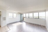 Located at 14255 Boulevard Gouin Ouest in Montréal, this well-organized 2-bedroom, 2-bathroom unit offers a practical and comfortable layout across a single floor. Light grey laminate flooring flows consistently throughout the main living areas and bedrooms, creating a clean, cohesive aesthetic. The spacious living room is bathed in natural light through large windows and sliding glass doors that open onto a balcony, offering expansive panoramic views of the surrounding landscape and waterway. A wall-mounted air conditioning unit ensures year-round comfort. The kitchen features a classic U-shaped layout with abundant white cabinetry, white tile backsplash, neutral countertops, and light ceramic tile flooring — offering generous storage and workspace. The primary bedroom is a comfortable size, with soft grey walls, light flooring, and a built-in sliding-door closet. The second bedroom also features grey-toned walls, light wood flooring, and large windows with open views. Two bathrooms serve the unit: one includes a full bathtub with large-format beige tile surround, while the second features a modern glass-enclosed shower with matching tile finishes. A hallway with a dedicated closet connects the rooms. The overall ambiance is bright, neutral, and move-in ready.