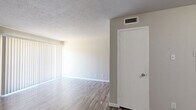 This single-floor, 1-bedroom, 1-bathroom unit offers a functional and efficient layout designed to maximize every square foot. Wood-look laminate flooring runs consistently throughout the space, providing a cohesive and easy-to-maintain surface across all rooms.

The combined living and dining area is the largest open space in the unit, featuring a textured ceiling, neutral taupe walls, and a large sliding glass door dressed with vertical blinds that allow for natural light control. The galley-style kitchen is efficiently arranged with white cabinetry lining both sides, granite-look countertops, black appliances including an electric range and full-size refrigerator, and a dedicated pantry for added storage.

The bedroom is a comfortable, well-proportioned room with neutral walls, wood-look flooring, and a window fitted with horizontal blinds. It benefits from generous closet space, including a walk-in closet equipped with built-in shelving and dual hanging rods on each side. Two additional closets provide further storage throughout the unit.

The bathroom features a full tub-shower combination with white tile surround and brushed nickel fixtures. A hallway connects the main living areas to the private spaces, completing this thoughtfully laid-out unit.
