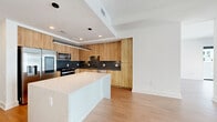 This contemporary 880 square foot apartment in Atlanta offers a harmonious blend of style and functionality. The open-concept layout maximizes space, with the living room seamlessly flowing into the kitchen area. Floor-to-ceiling windows flood the rooms with natural light and provide stunning city views, enhancing the sense of spaciousness.

The gourmet kitchen boasts sleek wooden cabinetry, contrasting beautifully with dark marble countertops and backsplash. High-end stainless steel appliances and a central island complete this culinary haven. The living area features warm wood flooring, creating a cozy yet modern ambiance.

The bedroom, measuring 130 square feet, continues the apartment's minimalist aesthetic with ample space and large windows. A well-appointed bathroom showcases a floating vanity with dual sinks, large mirrors, and modern fixtures. The apartment also includes a walk-in closet with custom shelving for optimal organization.

Throughout the space, crisp white walls and recessed lighting contribute to the clean, contemporary feel. A ceiling fan in the main living area provides both style and functionality. This thoughtfully designed apartment offers urban living at its finest, perfect for those seeking a modern, low-maintenance lifestyle in the heart of Atlanta.