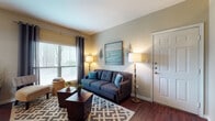Located at 830 Fasken Blvd in Laredo, Texas, this single-floor residence offers a thoughtfully designed layout that balances comfort and functionality throughout. Rich, dark hardwood-style flooring runs consistently across the entire unit, lending a warm and cohesive aesthetic to every room.

The living room is bright and welcoming, featuring vaulted ceilings, large windows dressed with blinds and grommet-top curtains, and ample space for relaxed seating arrangements. It flows seamlessly into the dining area, which is illuminated by a classic chandelier and surrounded by windows on multiple sides, filling the space with natural light. A patio door in the dining room provides direct outdoor access.

The galley-style kitchen is efficiently organized with warm wood cabinetry, granite-style countertops, and white appliances including a refrigerator, stove, dishwasher, and built-in microwave. A dedicated in-unit laundry area with a stacked washer and dryer is conveniently accessible directly from the kitchen.

The bedroom is a comfortable retreat with a ceiling fan, vaulted ceilings, and a large window that brings in natural light. The bathroom features a full tub and shower combination with tiled surround, hardwood-style flooring, and a vanity with granite-style countertops and warm wood cabinetry, providing practical storage.