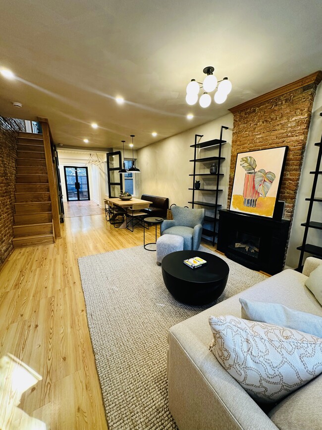 Living room with electric fireplace through to dining area, kitchen, and back patio - 615 S Bambrey St Townhome