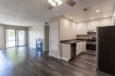 Located at 39930 Whitewood Rd in Murrieta, California, this single-floor residence offers a well-designed layout with functional living spaces throughout. The open living area makes an immediate impression with rich wood-style plank flooring, warm neutral-toned walls, and a standout fireplace framed in slate-style tile — a central focal point ideal for relaxed evenings. A ceiling fan overhead adds comfort, and a sliding glass door allows natural light to fill the space while providing outdoor access.

The kitchen is thoughtfully appointed with white shaker-style cabinetry, dark countertops, recessed lighting, and a full suite of stainless steel appliances including a gas range and refrigerator. The layout maximizes counter and storage space efficiently.

The bedrooms feature plush carpeting and mirrored sliding closet doors that enhance the sense of space. Natural light filters in through large windows dressed with vertical blinds, creating a bright and comfortable atmosphere. The in-unit laundry area adds everyday convenience.

The bathroom is clean and well-finished, featuring a wide vanity with granite-style countertops, white cabinetry, a large mirror, and a full tub-shower combination. Wood-style flooring ties the bathroom's design cohesively to the rest of the home. Overall, the residence presents a move-in-ready interior with consistent, modern finishes throughout.