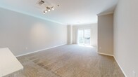 Located at 1000 Presidents Way in Dedham, Massachusetts, this single-floor residence offers a thoughtfully designed layout with a clean, neutral aesthetic throughout. The open-concept living and dining area is generously proportioned, featuring plush wall-to-wall carpeting, crown molding, and track lighting. A sliding glass door floods the space with natural light and provides access to an outdoor balcony.

The kitchen is a standout feature, showcasing warm wood cabinetry, quartz countertops with a tile backsplash, and a full suite of stainless steel appliances including a refrigerator, microwave, and range. A peninsula with a built-in sink and pendant lighting creates a natural divide between the kitchen and living area, ideal for casual dining or entertaining.

The bedroom is bright and comfortable, with two windows allowing ample natural light and soft carpeted flooring underfoot. A generously sized walk-in closet with wire shelving and hanging rods provides excellent storage capacity.

The bathroom is finished with wood-toned cabinetry, white quartz countertops, a large framed mirror, and wood-look flooring. A full tub-shower combination with white tile completes the space. Throughout the residence, consistent finishes and a warm neutral palette create a cohesive and inviting atmosphere.