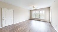 Located at 6354 Township Drive in Hollins, VA, this well-appointed 2-bedroom, 2-bathroom residence offers a thoughtfully designed single-floor layout. The open-concept kitchen and living area serves as the heart of the home, showcasing rich wood cabinetry, granite countertops, stainless steel appliances including a range, microwave, and refrigerator, and a peninsula with a built-in sink — ideal for both cooking and casual dining. Pendant lighting accents the kitchen, while wood-style flooring extends through the living area, which is brightened by a large multi-pane window and a ceiling fan overhead.

Both bedrooms are carpeted and feature neutral tones, ceiling fans, and ample natural light. The primary bedroom includes a spacious walk-in closet with wire shelving and hanging rods. The second bedroom offers dual doors, providing convenient access to storage or a hallway. Each bathroom is equipped with a vanity featuring wood cabinetry, and one includes a full tub-shower combination with tile flooring.

A dedicated laundry room houses a stacked washer and dryer unit, adding everyday convenience. Two hallways connect the living spaces efficiently. The overall aesthetic is clean, neutral, and move-in ready.