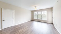 Located at 6354 Township Drive in Hollins, VA, this well-appointed 2-bedroom, 2-bathroom residence offers a thoughtfully designed single-floor layout. The open-concept kitchen and living area serves as the heart of the home, showcasing rich wood cabinetry, granite countertops, stainless steel appliances including a range, microwave, and refrigerator, and a peninsula with a built-in sink — ideal for both cooking and casual dining. Pendant lighting accents the kitchen, while wood-style flooring extends through the living area, which is brightened by a large multi-pane window and a ceiling fan overhead.

Both bedrooms are carpeted and feature neutral tones, ceiling fans, and ample natural light. The primary bedroom includes a spacious walk-in closet with wire shelving and hanging rods. The second bedroom offers dual doors, providing convenient access to storage or a hallway. Each bathroom is equipped with a vanity featuring wood cabinetry, and one includes a full tub-shower combination with tile flooring.

A dedicated laundry room houses a stacked washer and dryer unit, adding everyday convenience. Two hallways connect the living spaces efficiently. The overall aesthetic is clean, neutral, and move-in ready.