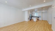 This well-appointed 3-floor residence offers a clean, modern aesthetic throughout, characterized by crisp white walls, recessed lighting, and a thoughtful layout across all levels. The ground floor features an attached two-car garage with a concrete floor, automated garage door opener, and a direct entry door into the home — providing both convenience and secure parking.

The main living level showcases an open-concept design that seamlessly connects the living area to a fully equipped kitchen. Light hardwood flooring runs throughout, complementing the kitchen's white shaker cabinetry, dark countertops, and a central island with bar seating. A full suite of stainless steel appliances — including a French door refrigerator, range, microwave, and dishwasher — adds a sleek, functional quality to the space. Natural light filters in through slatted window blinds, enhancing the bright, airy atmosphere.

The upper floor is home to the bedrooms, each finished with plush neutral carpeting and ceiling fans. A generously sized walk-in closet with built-in hanging rods provides ample storage. The full bathroom features a white vanity with dark countertops, an undermount sink, and a tub-shower combination. A stacked washer and dryer unit is conveniently located within the residence, completing this well-designed, move-in-ready home.