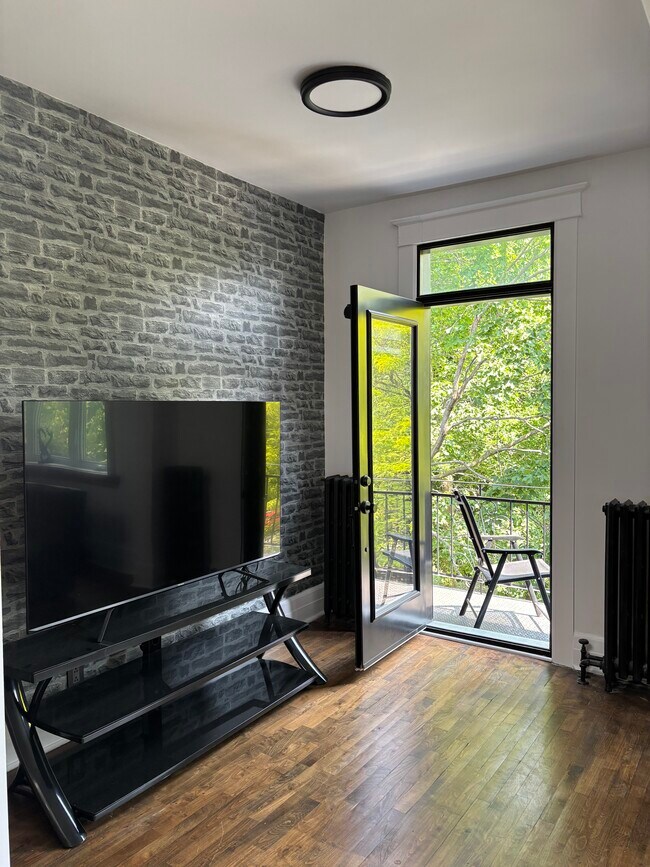 TV/ Den - front balcony in the trees - 846 Av Wiseman