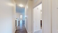 Located at 1389 W Centerton Blvd in Centerton, Arkansas, this single-floor residence offers a clean, modern aesthetic with thoughtfully selected finishes throughout. The layout flows seamlessly from room to room, connected by a bright hallway with wood-look flooring and crisp white walls.

The kitchen is a standout feature, equipped with rich dark wood cabinetry, marble-style countertops, a classic subway tile backsplash, and a full suite of stainless steel appliances including a range, microwave, dishwasher, and refrigerator. A peninsula with additional counter space adds both functionality and visual appeal.

The living areas continue the wood-look flooring and are filled with natural light from large windows dressed with blinds. A glass-paneled exterior door provides convenient access to the outdoors. Bedrooms are carpeted for comfort, each featuring ceiling fans and ample closet space, with windows that invite natural light.

Both bathrooms are finished with the same dark wood vanities and marble-style countertops found in the kitchen, complemented by tub-shower combinations and wood-look flooring. The consistent design language across the space creates a cohesive and polished look throughout this well-maintained Centerton residence.