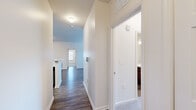 Located at 1389 W Centerton Blvd in Centerton, Arkansas, this single-floor residence offers a clean, modern aesthetic with thoughtfully selected finishes throughout. The layout flows seamlessly from room to room, connected by a bright hallway with wood-look flooring and crisp white walls.

The kitchen is a standout feature, equipped with rich dark wood cabinetry, marble-style countertops, a classic subway tile backsplash, and a full suite of stainless steel appliances including a range, microwave, dishwasher, and refrigerator. A peninsula with additional counter space adds both functionality and visual appeal.

The living areas continue the wood-look flooring and are filled with natural light from large windows dressed with blinds. A glass-paneled exterior door provides convenient access to the outdoors. Bedrooms are carpeted for comfort, each featuring ceiling fans and ample closet space, with windows that invite natural light.

Both bathrooms are finished with the same dark wood vanities and marble-style countertops found in the kitchen, complemented by tub-shower combinations and wood-look flooring. The consistent design language across the space creates a cohesive and polished look throughout this well-maintained Centerton residence.