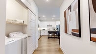 Located in Gallatin, Tennessee, this thoughtfully designed single-story home offers two bedrooms, two bathrooms, and a functional layout that maximizes every square foot. The open-concept kitchen and living area serves as the heart of the home, featuring crisp white shaker cabinetry, granite countertops, a subway tile backsplash, stainless steel appliances, and a central island with bar seating — ideal for both everyday meals and entertaining. Light wood-style flooring runs throughout, lending warmth and visual continuity to the space. The living room is bright and welcoming, with large windows and a glass door that flood the area with natural light and provide views of the surrounding neighborhood. The primary bedroom is generously sized, benefiting from multiple windows that invite abundant sunlight. The second bedroom is equally comfortable, with its own window and dedicated closet. Both bathrooms are finished with granite-topped vanities and wood-tone flooring, maintaining a consistent, clean aesthetic. A dedicated laundry room with full-size washer and dryer hookups adds everyday convenience. Two closets provide ample storage throughout the home. The overall ambiance is modern, light-filled, and move-in ready.