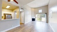 This thoughtfully designed single-floor home offers four bedrooms and two full bathrooms within a compact, well-organized layout. Light wood-tone flooring runs consistently throughout, creating a cohesive and airy feel across every room.

The combined living and dining area serves as the heart of the home, highlighted by a fireplace with a classic black surround, soaring ceilings, and a sliding glass door that opens to a balcony with outdoor views. Natural light fills the space through multiple windows fitted with vertical blinds. A ceiling fan adds practical comfort to the living area.

The kitchen is efficiently laid out with white shaker cabinetry, white quartz countertops, a stainless steel undermount sink with a modern pull-down faucet, and a full suite of stainless steel appliances including a gas range, over-the-range microwave, dishwasher, and refrigerator.

A central hallway connects the four bedrooms, each featuring ceiling fans and closets with built-in shelving and hanging rods. The primary bedroom is well-proportioned and includes dedicated closet storage. Both bathrooms are finished with white vanities, quartz countertops, and tub-shower combinations, offering clean, functional design. Neutral warm-gray wall tones and white trim complete the polished, move-in-ready aesthetic throughout the home.