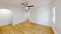 Located at 21 Arnold Park in Rochester's vibrant 14607 neighborhood, this 2-bedroom, 1-bathroom unit offers a clean, modern aesthetic throughout its efficiently designed single floor. Light hardwood flooring runs continuously through the living areas, bedrooms, and hallways, lending warmth and cohesion to the bright, white-walled interior.

The living room is a comfortable, open space anchored by a ceiling fan with a brushed gold fixture and an arched entryway that adds a classic architectural touch. Natural light flows in through multiple windows fitted with white blinds, enhancing the airy atmosphere.

The kitchen is a standout feature, outfitted with white shaker-style cabinetry, open corner shelving, glass-front upper cabinets, stainless steel appliances including a refrigerator and dishwasher, and a charming powder-blue subway tile backsplash. A window above the counter fills the space with natural light.

Both bedrooms continue the consistent hardwood flooring and white palette, with windows that bring in natural light. The primary bedroom offers a comfortable footprint with room for standard furnishings. A dedicated pantry provides additional storage, a practical bonus in a compact layout.

The bathroom features a clean, white tiled tub and shower surround. Two hallways connect the rooms efficiently, completing this well-organized and attractively updated unit.