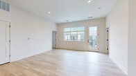 Located at 35 Flax St in Delaware, Ohio, this thoughtfully designed 2-bedroom, 2-bathroom home offers a clean, modern aesthetic throughout its single-floor layout. The open-concept living and kitchen area serves as the heart of the home, featuring light hardwood flooring, recessed lighting, and large windows that invite abundant natural light. A glass-panel door leads to a private balcony, extending the living space outdoors. The kitchen is well-appointed with white shaker cabinetry, a tile backsplash, stainless steel appliances, a central island with pendant lighting overhead, and a black-accented sink — combining style with functionality. A welcoming entrance hall connects seamlessly to the main living areas. Both bedrooms are carpeted for comfort and feature ample natural light; the primary bedroom is generously sized and includes access to a walk-in closet with wire shelving systems. Additional closets throughout the home provide excellent storage. The bathrooms are finished in crisp white with light tile flooring and matte black fixtures. A dedicated laundry area adds everyday convenience. The home's consistent palette of whites and warm neutrals creates a bright, airy atmosphere throughout.