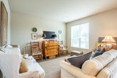 Located at 104 Lincoln St in Verona, WI, this well-appointed single-floor residence offers three bedrooms, three bathrooms, and a thoughtfully designed layout that maximizes comfort and functionality. The open-concept living, dining, and kitchen area serves as the heart of the home, featuring rich dark-wood cabinetry, granite countertops, stainless steel appliances, pendant lighting, and wood-look flooring that flows seamlessly throughout the main living spaces. Large sliding glass doors in the dining area flood the space with natural light and provide direct access to the private patio, which overlooks lush landscaping and tree-lined surroundings. The bedrooms are carpeted and bright, with large windows framing outdoor views and ceiling fans for added comfort. The primary bedroom offers a generous footprint with ample closet space. The bathrooms are elegantly finished with warm wood-tone flooring, wide vanities, and classic decorative accents. A dedicated laundry area houses a full-size washer and dryer, adding everyday convenience. With six closets distributed throughout, storage is plentiful. The residence combines a warm, classic aesthetic with practical modern amenities, making it a comfortable and inviting place to call home.
