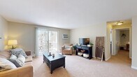 Located at 2 Robinson Rd in Rocky Hill, Connecticut, this single-floor, 2-bedroom, 1-bathroom residence offers a thoughtfully arranged layout that maximizes functionality across its compact footprint. Neutral-toned walls and wall-to-wall carpeting throughout the main living areas create a cohesive, understated aesthetic.

The combined living and dining area serves as the social heart of the home. The living room features a sliding glass door that opens to a private balcony, allowing natural light to fill the space and providing outdoor access. The dining area is defined by an elegant chandelier overhead, adding a refined touch. Together, these spaces offer a comfortable, open feel.

The kitchen features warm wood cabinetry, dark countertops, tile flooring, and white appliances including a range and refrigerator, providing generous storage and workspace in a galley-style configuration.

The primary bedroom offers a comfortable footprint with two closets and neutral carpeting. The second bedroom also features dual closets and similarly soft, neutral finishes. Both rooms are quiet and well-proportioned.

The bathroom includes a tiled tub-shower combination with clean, simple finishes. A connecting hallway efficiently links all rooms, completing this practical and comfortable layout.