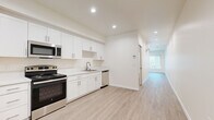Located at 5310 Adobe Falls Rd in San Diego, CA, this efficiently designed single-floor unit offers a clean, contemporary aesthetic with a neutral color palette and light wood-style flooring that runs consistently throughout the space.

The kitchen is a standout feature, boasting a full suite of stainless steel appliances including a refrigerator, electric range, over-the-range microwave, and dishwasher. Crisp white shaker-style cabinetry extends from floor to ceiling, providing ample storage, while light countertops and a single-basin sink complete the functional layout. Recessed lighting illuminates the kitchen and hallway, creating a bright and welcoming atmosphere.

The living area is open and versatile, bathed in natural light from a large window fitted with vertical blinds. The entry area includes a dedicated electrical panel and thermostat, adding practical convenience. The bathroom is well-appointed with a white vanity featuring a granite-style countertop, a full tub-and-shower combination with chrome fixtures, and a recessed ceiling light. Throughout the unit, clean white walls and wide baseboards contribute to the modern, move-in-ready feel. The overall design prioritizes simplicity, functionality, and brightness.