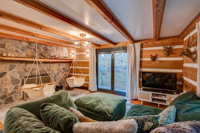 Sala de estar con chimenea y sillas colgantes. - 1444 Rich Mountain Rd