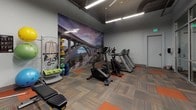 Located at 1125 Avenue of the Oaks in Sparks, Nevada, this fitness center is a well-equipped, single-floor facility designed to support a full range of workout routines. The space features an industrial-style aesthetic, with exposed ductwork and ceiling infrastructure complemented by clean gray walls and bright linear fluorescent lighting that ensures excellent visibility throughout.

The flooring consists of a distinctive patterned carpet tile in a mix of orange and multi-tone gray hues, adding visual energy to the space. A large floor-to-ceiling mirror occupies one wall, accompanied by a bold motivational "FOCUS" wall decal, enhancing the sense of depth and encouraging a results-driven atmosphere.

Cardio equipment is well-represented, with multiple treadmills, an upright stationary bike, and an elliptical machine arranged along one side of the room. A dramatic full-wall photographic mural of a scenic bridge and rocky landscape serves as a striking backdrop for this cardio zone. On the strength side, the facility includes a multi-station cable machine, a full rack of hex dumbbells, an adjustable weight bench, and an assortment of medicine balls, resistance bands, and foam rollers neatly organized on a dedicated rack. Black-and-white athletic photography adorns the walls, reinforcing the fitness-focused environment throughout.