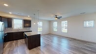 Located at 2601 Sandersville Rd in Lexington, Kentucky, this well-appointed two-story home offers a thoughtfully designed layout with contemporary finishes throughout. The main level showcases an open-concept living and kitchen area bathed in natural light from multiple windows with blinds. The kitchen is a standout feature, equipped with rich dark cabinetry, granite countertops, a tile backsplash, stainless steel appliances including a range, microwave, and dishwasher, and a central island with pendant lighting overhead. Light wood-look flooring flows seamlessly through the main living area, complemented by a ceiling fan that adds both comfort and style. The upper level features bright, well-sized bedrooms with generous closet space and the same wood-look flooring. The bathrooms are finished with granite countertops and dark vanity cabinetry, maintaining a cohesive design aesthetic. A dedicated laundry room with wire shelving and washer/dryer hookups adds everyday convenience. The home also includes an attached two-car garage with an automatic opener. Throughout both floors, neutral walls and recessed lighting create a clean, move-in-ready atmosphere suited for a variety of lifestyles.