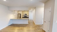 This contemporary 1090 square foot apartment in Charlotte, NC offers a thoughtfully designed living space. The open-concept floor plan seamlessly integrates the kitchen, living, and dining areas, creating an airy atmosphere. The kitchen boasts sleek light-colored cabinetry, stainless steel appliances, and an expansive granite countertop with a breakfast bar.

Both bedrooms are generously sized, with the primary bedroom measuring 200 square feet. The bathrooms feature modern fixtures and finishes. The apartment includes a convenient in-unit laundry area with full-sized appliances and a dedicated closet for additional storage.

Throughout the space, wood-look flooring adds warmth and durability. Large windows in the living areas and bedrooms allow ample natural light to flood the interior. Climate control is ensured with both ceiling fans and wall-mounted air conditioning units.

The neutral color palette of the walls provides a blank canvas for personalization. Notable features include a mix of recessed lighting and pendant fixtures, window blinds for privacy, and multiple closet spaces for organization.

This single-story apartment combines functionality with contemporary design, offering a comfortable and stylish living environment in a desirable Charlotte location.