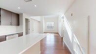 This contemporary townhouse in Norwood, MA offers 1180 square feet of living space across two floors. The main level boasts an open-concept design, featuring a modern kitchen with sleek dark wood cabinetry, stainless steel appliances, and a central island. The kitchen flows seamlessly into the living area, both adorned with warm wood flooring that adds a touch of elegance.

Upstairs, the 130 square foot primary bedroom provides a tranquil retreat, complete with plush carpeting and ample natural light from multiple windows. The bathroom showcases a clean, modern aesthetic with a spacious vanity and a shower/tub combination.

Throughout the home, neutral tones create a bright and airy atmosphere. The property benefits from high ceilings, recessed lighting, and strategically placed windows that flood the interiors with natural light. A staircase connects both levels, and additional features include a closet for storage and a hallway for easy navigation.

This well-designed townhouse strikes a perfect balance between comfort and style, offering a contemporary living space in a desirable location.