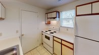 This single-floor residence offers a well-organized 2-bedroom, 2-bathroom layout designed for comfortable everyday living. The open living area features soft carpeting, neutral walls, and a classic brass chandelier, creating a bright and welcoming atmosphere. A large window and exterior door allow natural light to fill the space, while a pass-through counter connects the living area to the kitchen seamlessly.

The kitchen is equipped with white appliances, including an electric range and refrigerator, complemented by wood-trimmed cabinetry and light tile flooring. A window above the counter brings in additional natural light, and ample cabinet storage keeps the space practical and organized.

Both bedrooms are generously sized, featuring plush carpeting, textured ceilings, and windows that invite natural light. Each room offers a calm, neutral palette well-suited for a variety of uses.

The two bathrooms are finished with light tile flooring and wood-trimmed vanities. The full bathroom includes a shower-tub combination, toilet, and vanity with under-sink storage, while the second bathroom features a wide vanity with a large mirror and towel bar. A carpeted hallway connects the bedrooms and bathrooms, completing the efficient and functional floor plan of this residence.