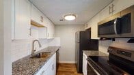 Located at 11723 Nansemond Ct in Louisville, Kentucky, this two-floor home offers a well-considered layout with thoughtfully updated interiors throughout. The kitchen stands as a highlight of the space, featuring white shaker-style cabinetry with brushed nickel hardware, granite countertops, a classic white subway tile backsplash, and a suite of stainless steel appliances including a refrigerator, electric range, built-in microwave, and dishwasher. Warm hardwood-style flooring runs through the kitchen and main living areas, adding a cohesive and inviting feel. The living and entry areas benefit from natural light, with a glass-paneled front door that brightens the main corridor. Closet storage is available on the main level, featuring louvered bi-fold doors. The bedrooms are carpeted for comfort and each receive generous natural light through blinded windows set against neutral gray walls. Textured ceilings are consistent throughout the home. The overall aesthetic is clean and neutral, providing a versatile backdrop well-suited for a variety of furnishing styles. The two-floor configuration offers a natural separation between living and sleeping areas, contributing to a functional and comfortable living environment.